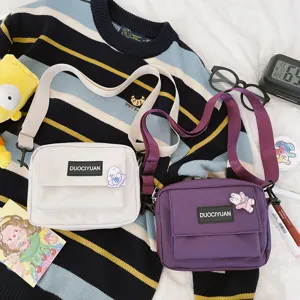Vista detallada de bolsos cruzados de lona estilo harajuku casual para estudiantes niñas.