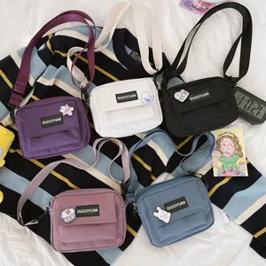Vista detallada de bolsos cruzados de lona estilo Harajuku coloridos para el uso diario.
