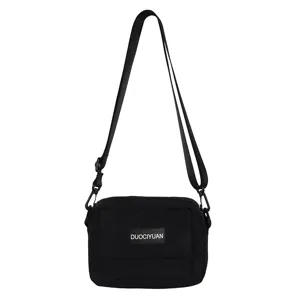 Clásico bolso bandolera negro de lona con correa ajustable y bolsillo frontal para uso diario.