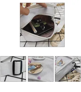 Detalle de bolso ita de lona blanca con ventana de malla, chapas de anime y hebilla de correa.
