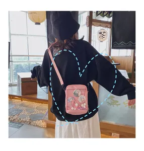 Detalle de bolso ita rosa con ventana frontal transparente y adorables chapas de anime lindas.