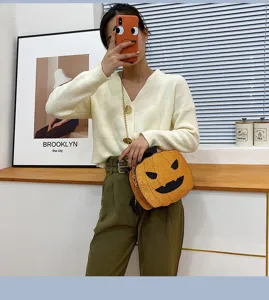 Halloween pumpkin crossbody bag with glossy reflective finish and funny face design for women.