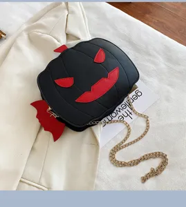 Detail view of Halloween pumpkin crossbody bag featuring cute devil wings and gold chain.