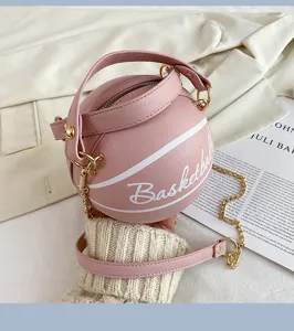 Detailansicht der rosa basketballförmigen Umhängetasche mit goldener Kette und Tragegriff.