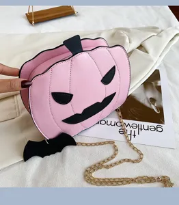 Detail shot of the pink Halloween pumpkin crossbody bag featuring cute bat wing and face design.
