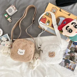 Detail view of fluffy lambswool crossbody bag featuring cute bear embroidery and strap.