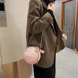 Detailansicht der kreativen pinken basketballformigen Umhangetasche mit goldener Kette im Einsatz.