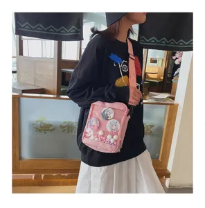 Bolso bandolera transparente kawaii estilo japonés rosa con chapas anime y pompones