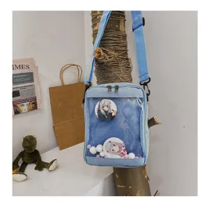 Detalles del bolso cruzado de lona azul claro con ventana transparente y pines de anime lindos.