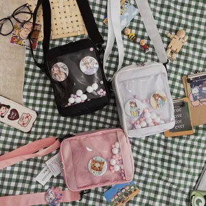 Vista detallada de bolsos ita transparentes de estilo japonés con chapas de anime y peluche.