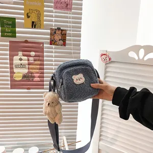 Detail shot of the cute plush sherpa crossbody bag featuring an adorable bear patch and pendant.