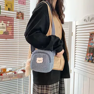 Detail shot of cute blue sherpa crossbody bag with fluffy bear patch and playful pendant.