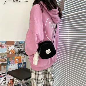Detailed view of a cute black sherpa crossbody bag with a sweet bear pendant for daily wear.