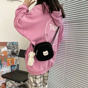 Black fluffy plush crossbody bag for women, cute bear pendant shoulder bag style.