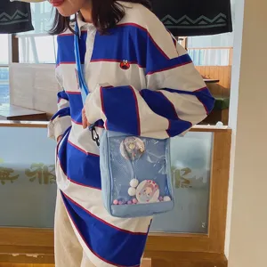 Bolso ita transparente japonés con adorables insignias de anime y polo a rayas.