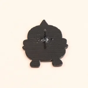 Gros plan sur le dos d'un pin's en émail en forme de hibou bronze avec fermoir de sécurité en métal.