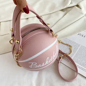Nahaufnahme der kreativen rosa Basketball Handtasche mit runder Form und goldenen Beschlägen.