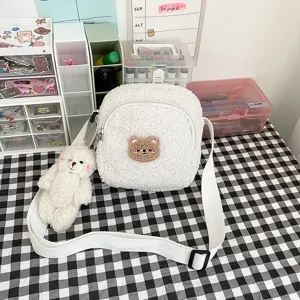 Close-up detail of the cute white lamb wool crossbody bag featuring a soft bear patch.