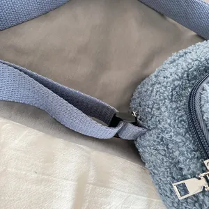 Blue lamb wool crossbody bag detail showing soft sherpa texture, adjustable strap and metal zipper.