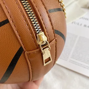 Detaillierte Nahaufnahme einer kreativen basketballförmigen Ledertasche mit goldenem Reißverschluss.