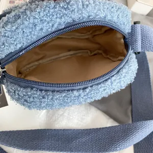 Close-up detail of blue fluffy sherpa crossbody bag interior lining and zipper structure.