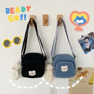 Close-up detail of cute sherpa crossbody bags with soft bear plush pendants and sweet bear face.