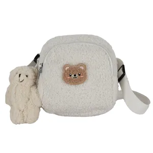 White lamb wool crossbody bag featuring cute bear embroidery and plush pendant detail.