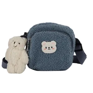 Detailed view of fluffy lamb wool crossbody bag with cute bear patch and plush pendant.