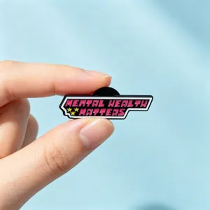 Gros plan de la broche en métal avec le slogan Mental Health Matters et un design rose vif.