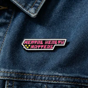 Gros plan de la broche en émail métallique avec le slogan mental health matters et étoiles.