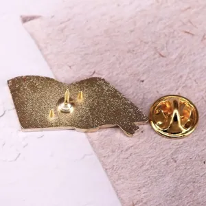 Gedetailleerd overzicht van de achterkant van de gouden metalen speld met vlindersluiting.