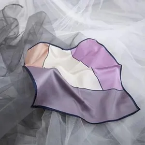 Dettaglio del raffinato foulard in seta liscia con elegante motivo geometrico e bordi scuri.