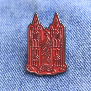 Detailed view of a Gothic cathedral enamel pin, red metal brooch for clothes and bags.