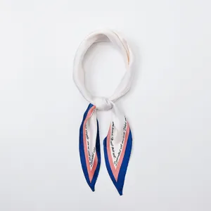 Vista detallada del elegante pañuelo de seda estrecho con borde azul rosa y texto.