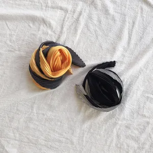 Pleated neck scarf detail showing fine texture, elegant folded design and soft fabric feel.