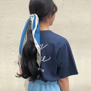 Vista detallada de un pañuelo para el pelo puntiagudo y elegante con estampados de letras.