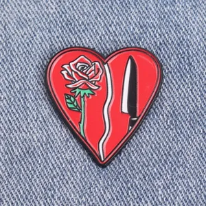 Dark romantic heart brooch featuring rose and dagger enamel design, bags and clothes.
