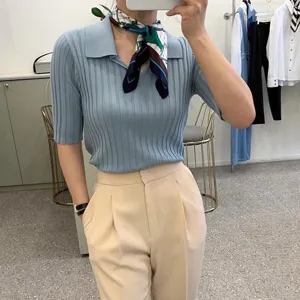 Vista dettagliata di un foulard in seta elegante con motivo di cavallo e polo in maglia.