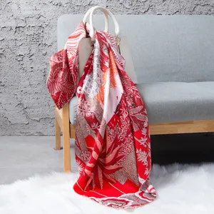 Detail shot of red orange silk square scarf featuring intricate tropical print design.