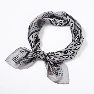 Detailaufnahme des grauen, seidenähnlichen Leopardenmuster-Quadratischals für Damen.