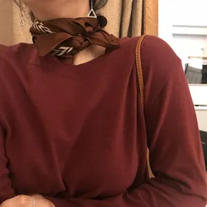 Caramel silk scarf with retro black and white stripes for women, stylish neck accessory detail.