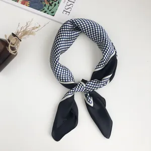 Detalle del pañuelo de seda azul con lunares geométricos, accesorio elegante y chic.