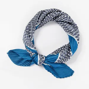 Blue pleated polka dot neck scarf detail shot, showing delicate texture and bow knot design.