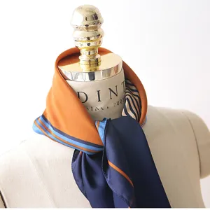Detailed view of women's silk satin scarf with contrast color and stylish striped design.