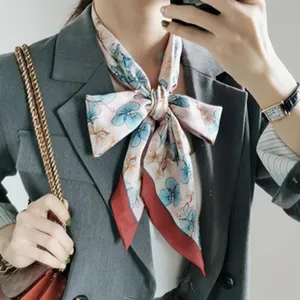 Pink floral silk scarf detail shot, elegant neck bow knot styling with gray blazer outfit.
