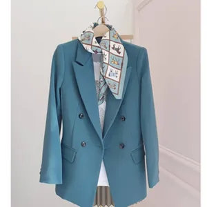 Gedetailleerd overzicht van de blauwgroene blazer gecombineerd met een stijlvolle paardensjaal.