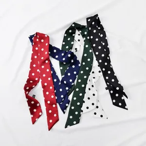Vista dettagliata di foulard in seta a pois, perfetti come nastri per borse o accessori.