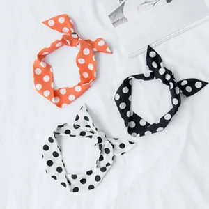 Primo piano dettagliato di nastri per capelli a pois e foulard da borsa in colori chic.
