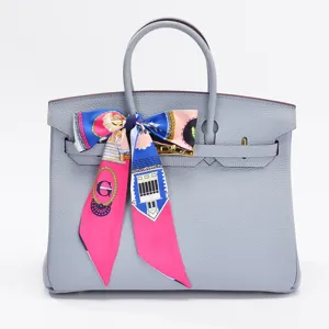 Borsa in pelle grigia con sciarpa twilly stampata colorata, stile di lusso classico.