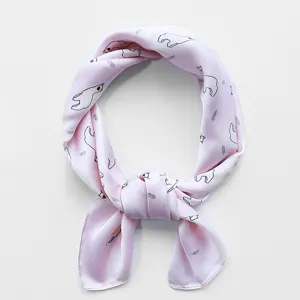 Detail van roze zijden sjaaltje met schattig alpaca-patroon en gladde textuur van de stof.